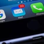 A close-up photo of a smartphone displaying popular apps like Google and Mail.