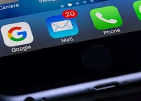 A close-up photo of a smartphone displaying popular apps like Google and Mail.